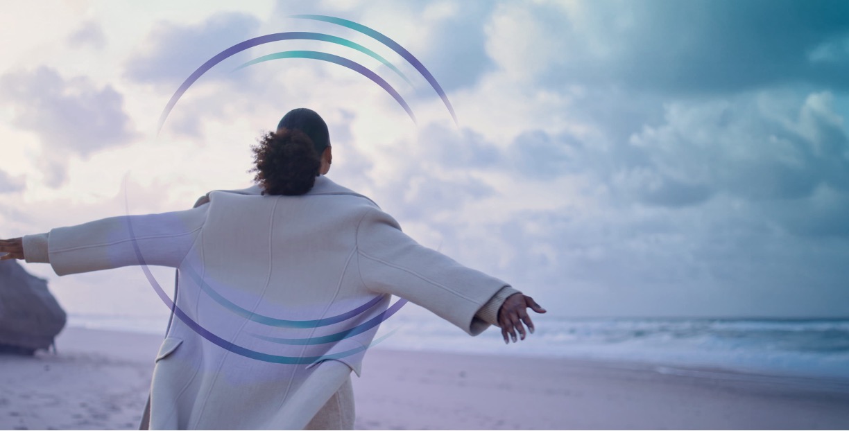 Person standing freely on a beach, representing the relief of reducing debt and reclaiming control of your financial future.