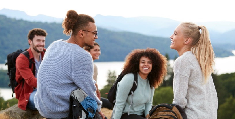 Friends enjoying a mountain hike, illustrating the financial price of postponing meaningful experiences and physical adventures until ‘someday’.