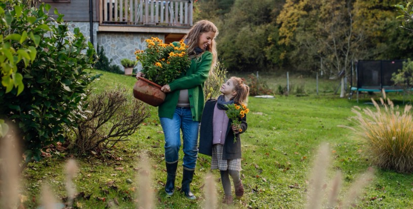 Mother and daughter carrying flowers together in a garden, representing family memories and the value that does not appear on financial statements.